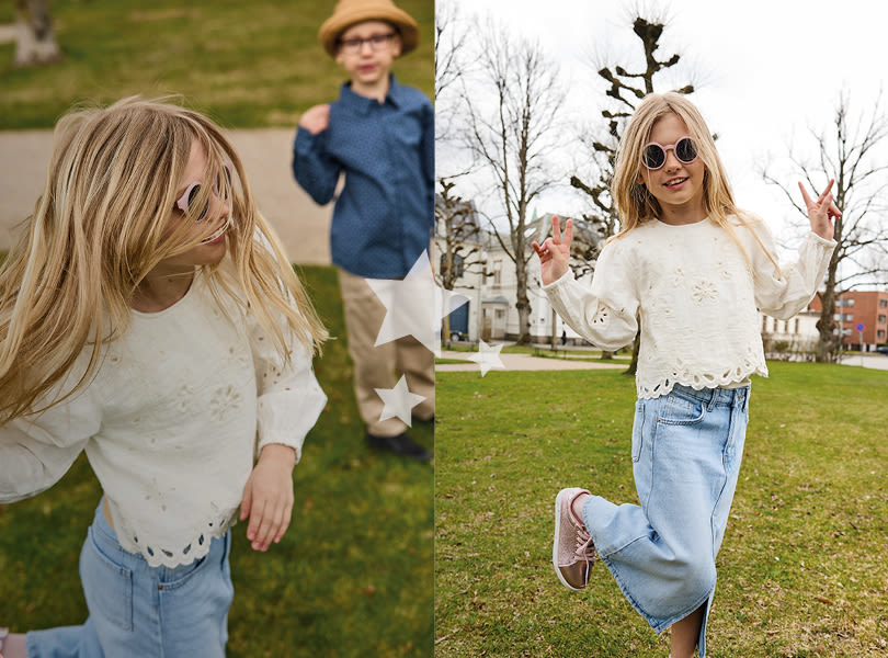 Barn i hvit genser og lyse jeans poserer utendørs, med rosa sneakers med hvite såler i casual stil.